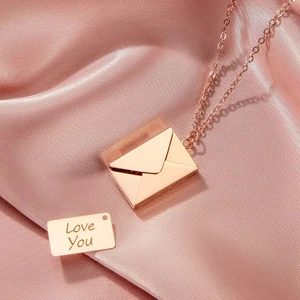 Rose gold envelope necklace with Love You engraved plate on pink satin background