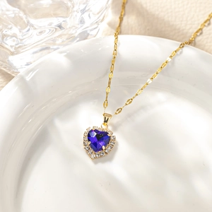 Detail of heart-shaped necklace with purple stone and micro-inlaid zircons on white plate