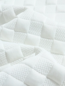 Macro shot of white knitted plaid fabric texture showing the quilted pattern on men's shirt