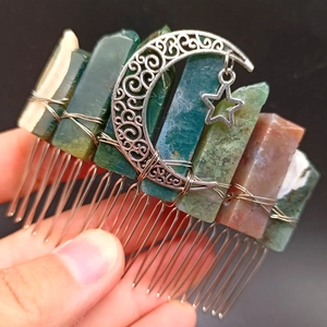 Detail of natural green crystal hair comb with silver moon and star charms