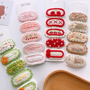 Detail of handcrafted knitted floral hair clips in various pastel colors and patterns