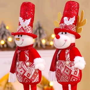 Détail de peluches de bonhomme de neige et renne avec chapeaux à paillettes rouges et carreaux