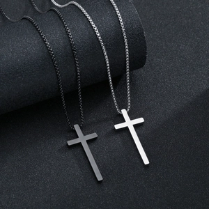 Detail of silver and black cross pendant necklaces with minimalist polished steel finish