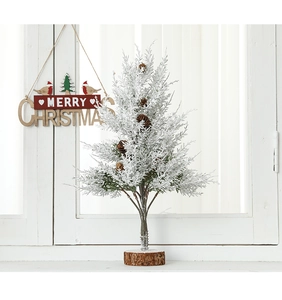 Mini artificial Christmas tree with snow flocking, pine cones, and a wooden base stand