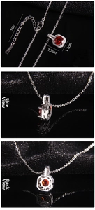 Detail view of red cubic zirconia pendant with dimensions 1.7cm x 1.1cm and S-STEEL mark
