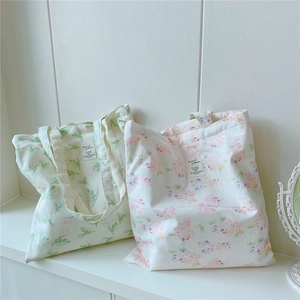 Detail of floral and leaf print cotton canvas tote bags with decorative woven labels