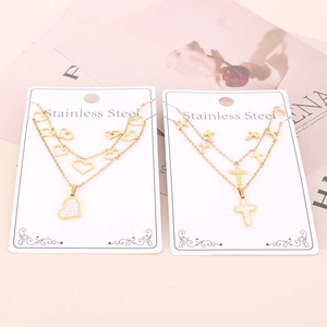 Detail of layered stainless steel gold necklaces with heart and cross pendants