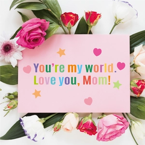 Macro detail of Mother's Day alphabet stickers with pink floral gift arrangement