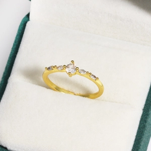 Detail eines Goldrings mit Zirkoniasteinen in einer grünen Samtschmuckschatulle