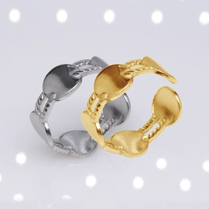 Macro detail of adjustable gold and silver chain rings with oval charms on white background