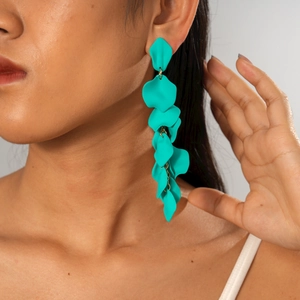 Detail of matte teal green floral drop earrings on model with multi-petal fringe design