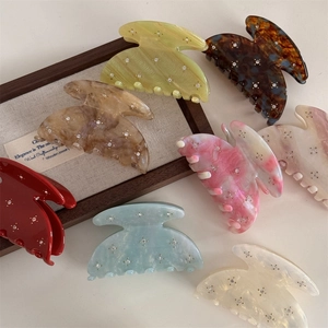 Medium acetate hair clips with rhinestones in multiple colors on a white surface