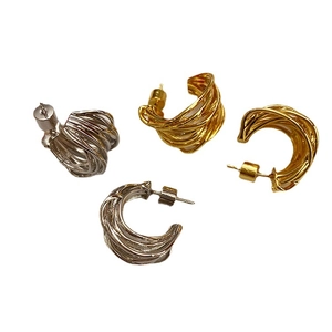 Intertwined gold and silver C-shaped twisted earrings with openwork textured design