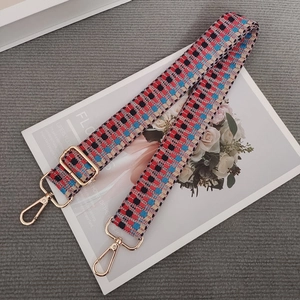 Close-up of bohemian colorful woven bag strap with golden metal lobster clasps