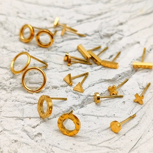 Detalle de set de pendientes geométricos minimalistas de acero inoxidable bañados en oro de 18K