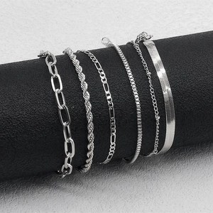 Detail of six silver minimalist chains including Cuban and Figaro styles on a display stand
