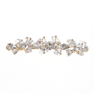 Detailed view of the sparkling crystal stones set in a gold-finished metal hair clip