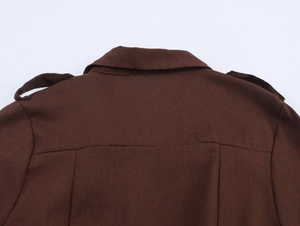 Close-up of dark brown utility dress back showing epaulets and textured cotton fabric