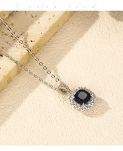 Primo piano della collana in argento S925 con ciondolo zaffiro blu su sfondo in pietra
