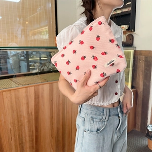 Détail de la texture velours côtelé et imprimé fraise sur un sac à main rose