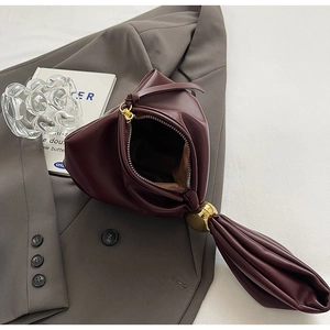 Detail view of wine red leather bucket bag with gold handle and zipper interior