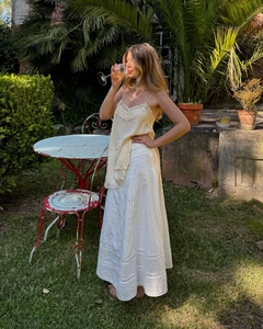 Detailed close-up of beige lace camisole paired with an embroidered white skirt
