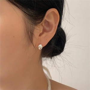 Macro shot of minimalist silver irregular lava shape studs in S925 sterling silver