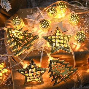 Golden Christmas LED string lights with hollow stars and trees on a gift box