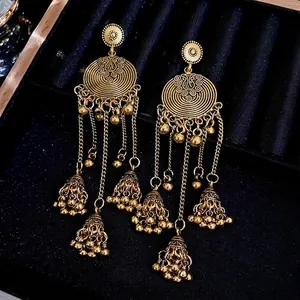 Vintage gold tassel earrings with floral scroll design and hollow bell pendants