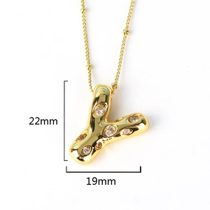 Macro detail of gold Y-shaped letter pendant with zircon stones and size dimensions