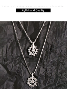 Detail of silver spinning snowflake pendant with micro-inlaid crystals on twisted chain