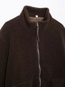 Detail of dark brown teddy fleece jacket with high collar and silver metal zipper