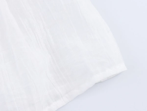 Close-up of white cotton fabric with vertical texture and delicate hem stitching detail