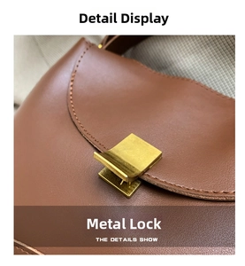 Detailed macro view of the golden metal buckle on a brown leather shoulder bag