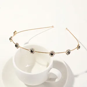 Detailed shot of golden leaf headband with black stones and crystals on white cup