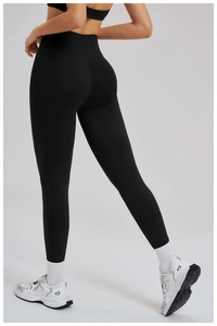 Détail du pantalon de yoga noir taille haute montrant le tissu élastique et l'effet sculptant