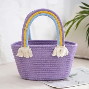 Close-up of purple woven handbag with rainbow handles and boho cotton tassels