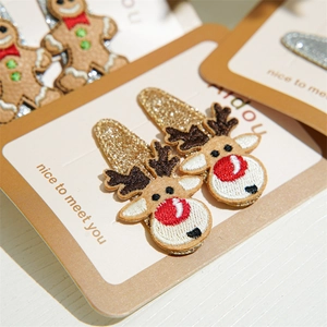 Detailed embroidery of Christmas reindeer and gingerbread man on festive hair clips