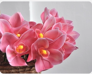Close-up of realistic pink 3D printed cymbidium orchid in a rustic woven flower basket