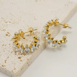 Detalle de pendientes de acero inoxidable 18K con circonitas de corte marquesa sobre piedra