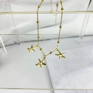 Detail of gold bead chain with three textured starfish pendants on an acrylic stand