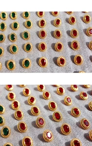 Detailed rows of vintage oval stud earrings with red and green gems in gold twisted frames