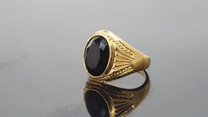 Detailed macro view of a vintage gold ring with a faceted oval black onyx gemstone inlay