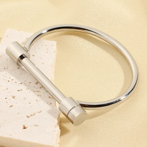 Polished silver stainless steel horseshoe U-lock bangle bracelet on stone background