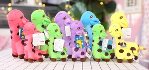 Colorful plush giraffe toys in pink, green, and blue with spots and suction cup details