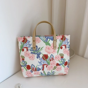 Detailed shot of pink rose and blue iris floral canvas tote with leather handle rivets