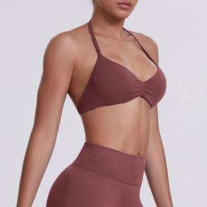 Detail view of seamless halter neck sports bra and high-waisted leggings in dark maroon