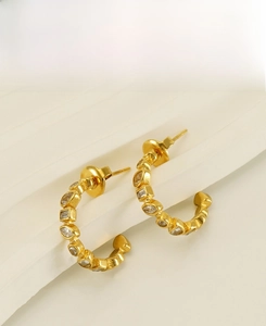 Detail showing the polished 18k gold-plated stainless steel earrings with zircon inlay