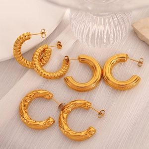 Three pairs of vintage gold geometric C-shaped hoop earrings with textured metal finishes
