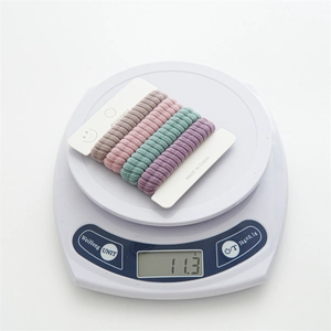 Weight measurement of 4 colorful seamless towel hair ties showing 11.3g on a scale